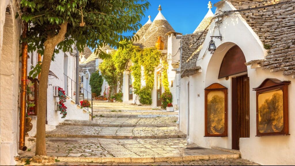 Traditional trulli houses with whitewashed walls and conical roofs in the UNESCO town of Alberobello, Puglia.