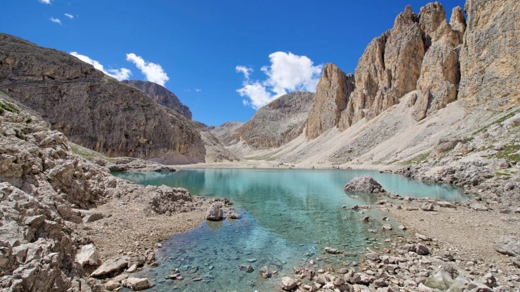 Lago di Antermoia in summer, showcasing stunning reflections and vibrant colors. Travel to the Dolomites to explore beautiful Alpine Lakes.