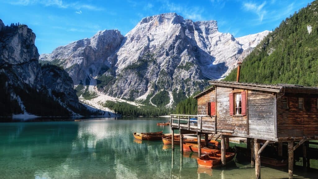 Lago di Braies with boats and majestic mountains in summer – Travel to the Dolomites featuring stunning Alpine Lakes