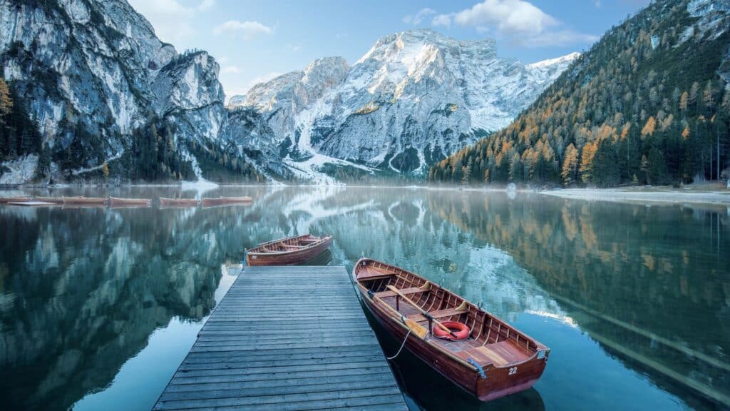 Lago di Braies on a beautiful winter day, showcasing snow-capped mountains, perfect for those interested in travel to the Dolomites and exploring Alpine lakes.