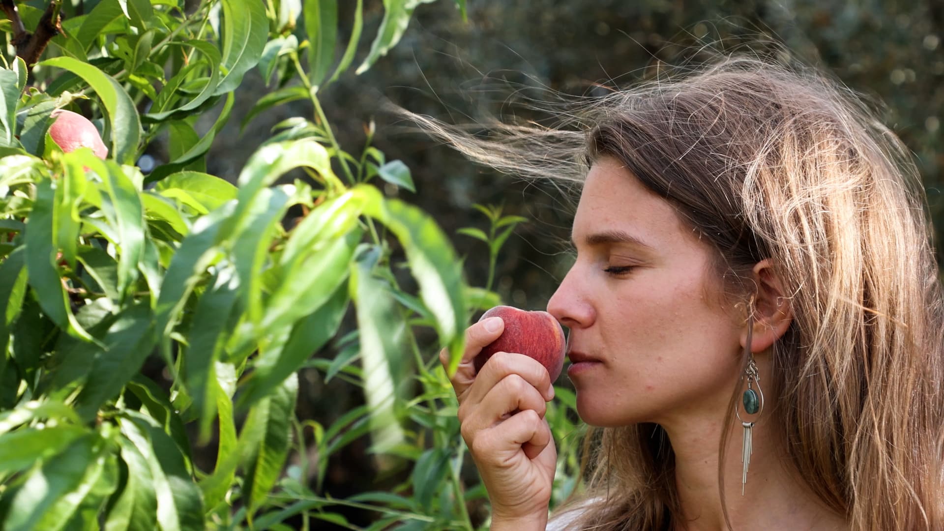 Karen enjoying the aroma of organic fruit, embodying the essence of Sensorial Travel™