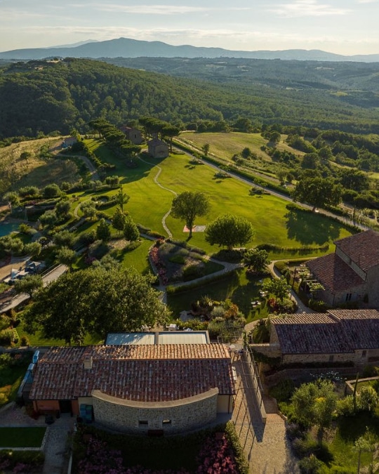 Scenic vineyard in Tuscany with rolling hills and ancient stone villas, showcasing the beauty of Umbria and Tuscany on a small group tour