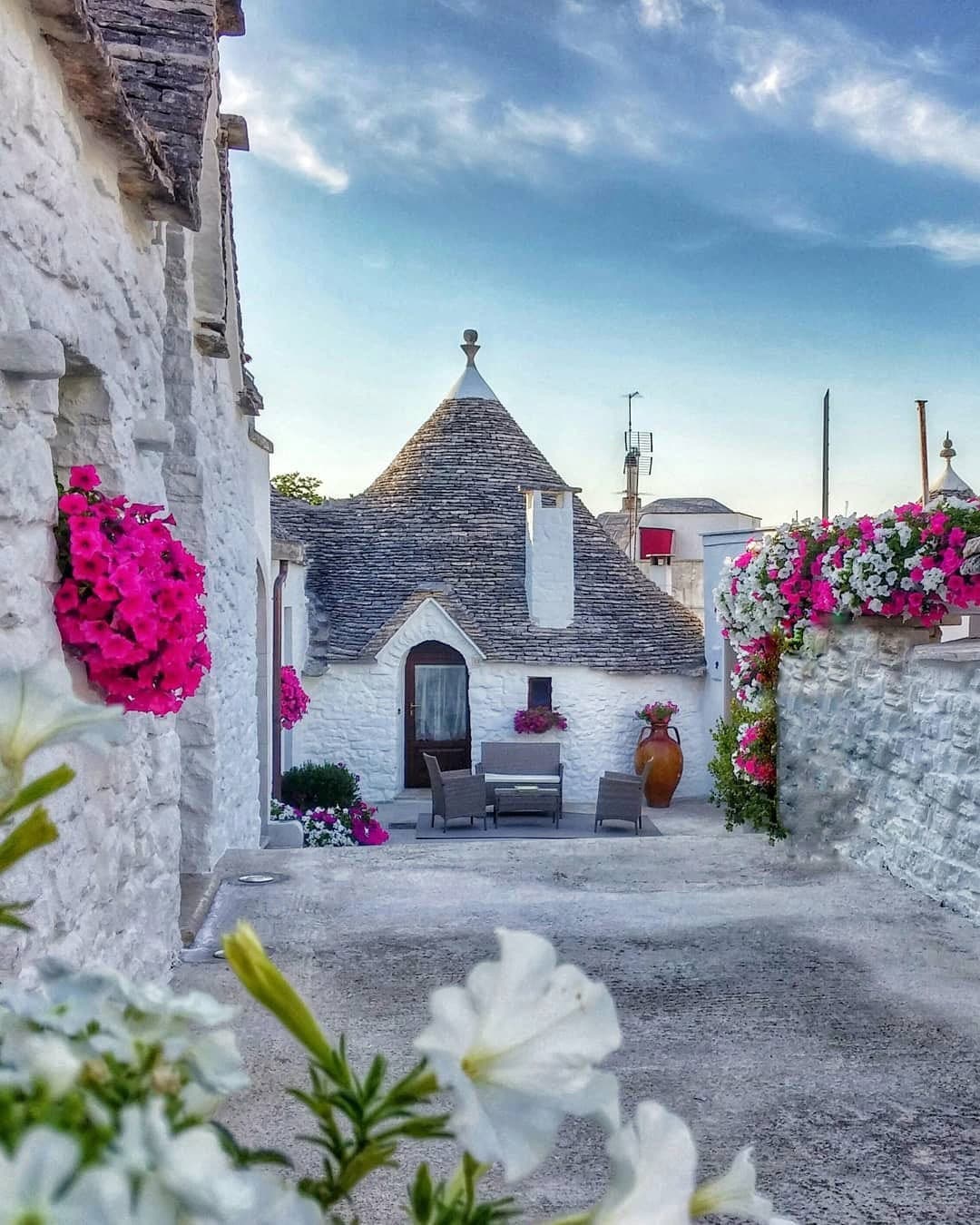 Panoramic view of historic Alberobello with ancient stone houses and winding streets, part of a small group tour in Puglia