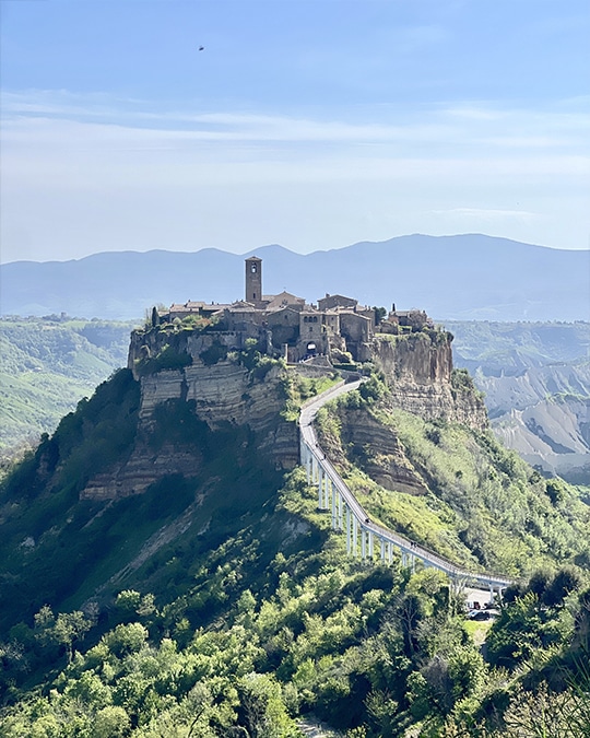 Scenic vineyard in Tuscany with rolling hills and ancient stone villas, showcasing the beauty of Umbria and Tuscany on a small group tour