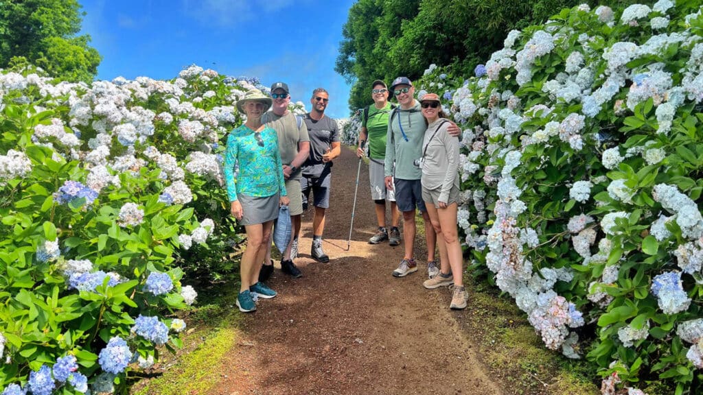 Participants On A Small Group Trip Hiking In The Azores Surrounded By Lush Greenery And Natural Beauty.