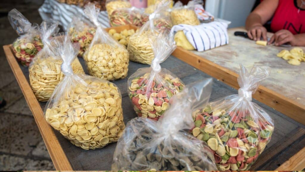 Local Women Making Orecchiette Pasta By Hand On The Streets Of Bari Vecchia, Showcasing Authentic Culinary Traditions In Puglia, Italy.