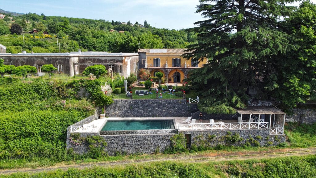 Barone Di Villagrande Vineyard Surrounded By Lush Greenery On The Slopes Of Mount Etna, An Example Of Sustainable Travel In Italy.