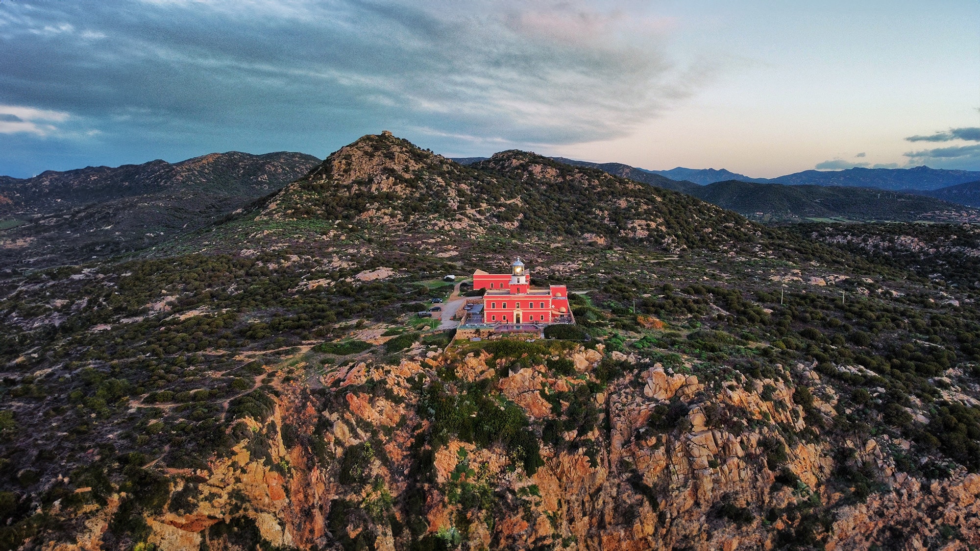 Faro Spartivento in Sardinia surrounded by greenery with a stunning view of the Mediterranean Sea, an example of sustainable travel in Italy.