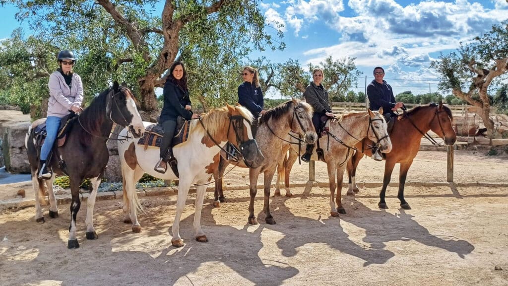 Small Group Tour In Puglia: Travelers Horseback Riding Along The Scenic Coastline And Countryside Of Italy'S Southern Region.