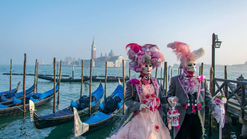 People wearing traditional Venetian masks during the Venice Carnival, embodying the city's timeless elegance beyond mass tourism.