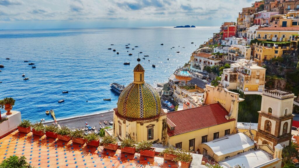 Visit Italy In 2025: The Best Destinations Beyond Rome 5 Positano On The Amalfi Coast, With Colorful Houses Cascading Down The Cliffs And The Serene Blue Waters Of The Mediterranean Below, Offering A Stunning View Of One Of Italy’s Most Iconic Coastal Destinations.